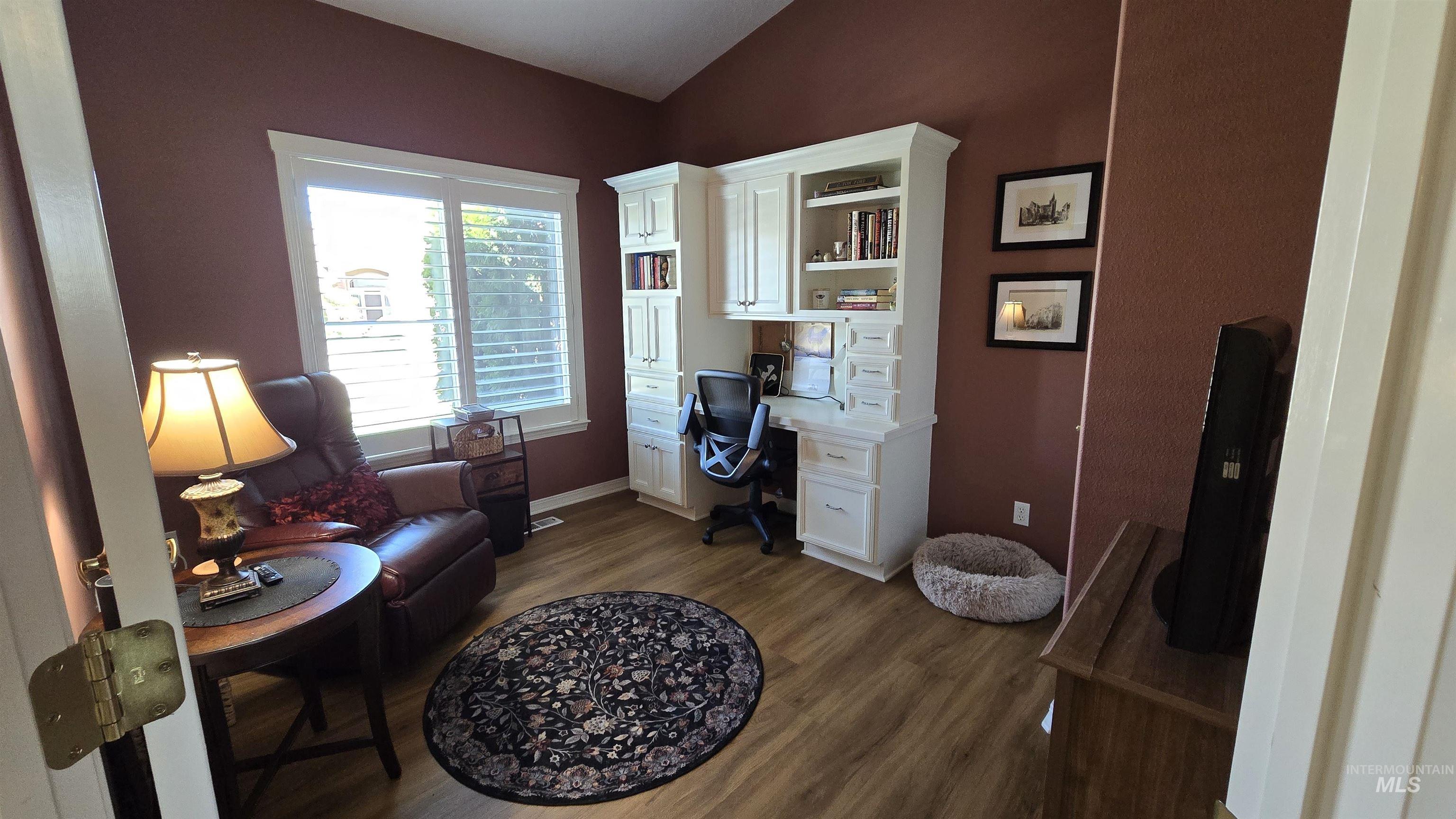 2898 North Silverleaf Way Meridian, ID 83646 - Photo 18 of 26 Home office with built in study area, dark wood-type flooring, and vaulted ceiling