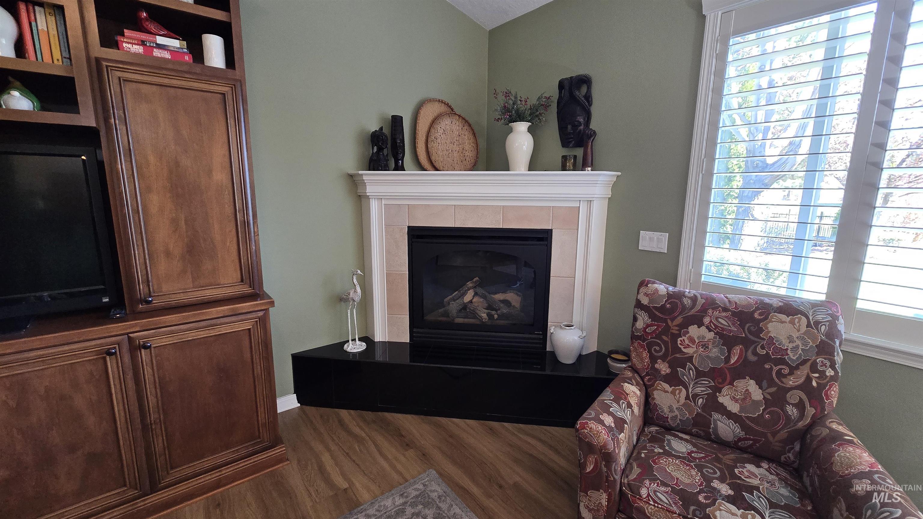 2898 North Silverleaf Way Meridian, ID 83646 - Photo 24 of 26 Living room with dark wood-style flooring and a fireplace