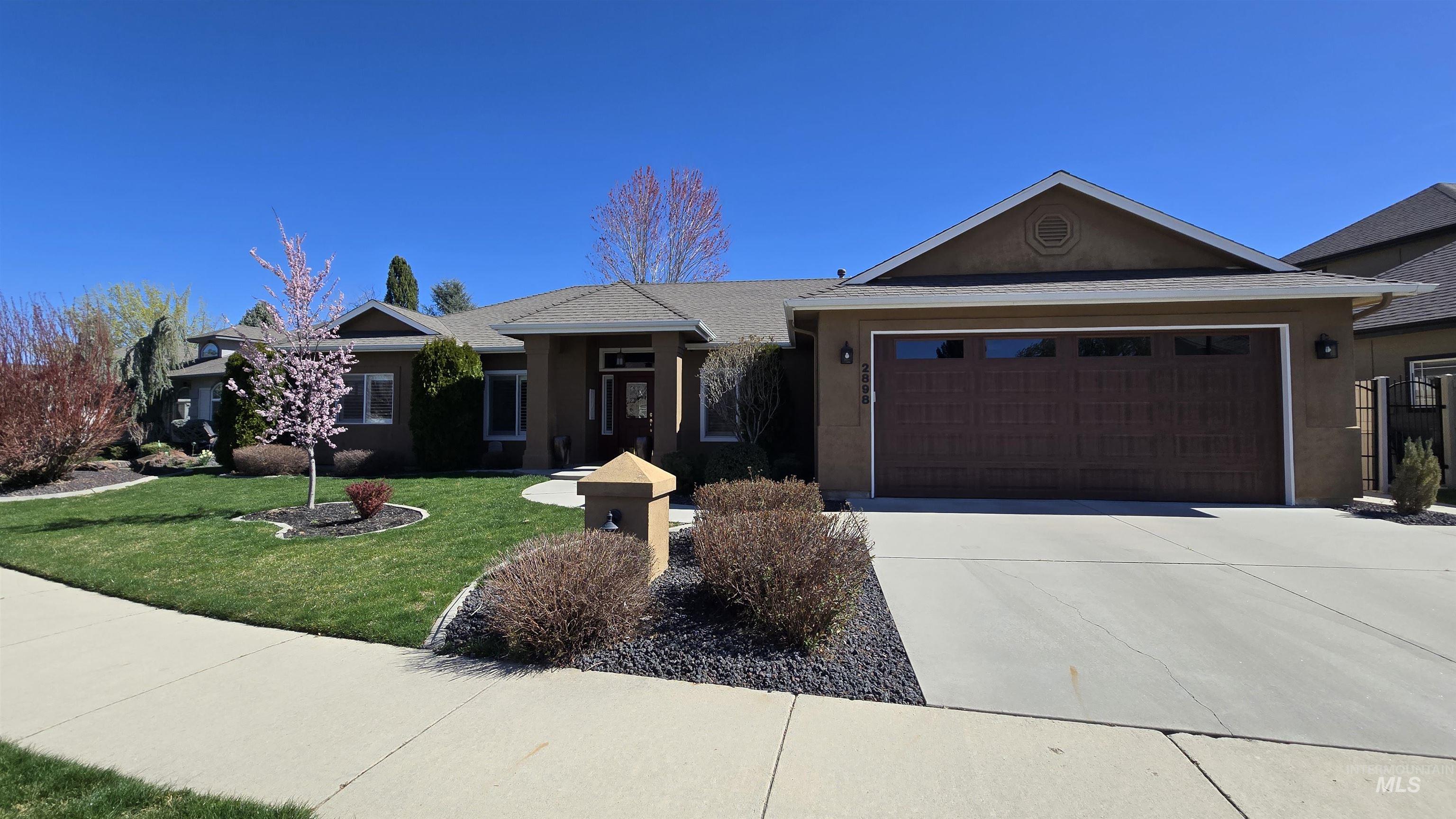 2898 North Silverleaf Way Meridian, ID 83646 - Photo 3 of 26 Single story home featuring an attached garage, stucco siding, driveway, and a front lawn