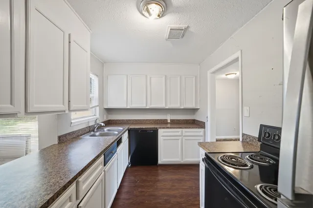 a kitchen with stainless steel appliances granite countertop a sink stove and cabinets