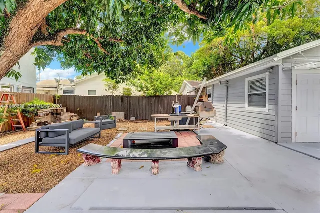 a backyard of a house with table and chairs