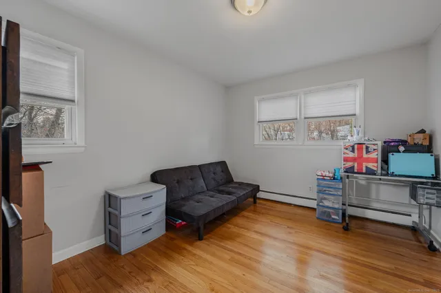 a view of an empty room with furniture and wooden floor