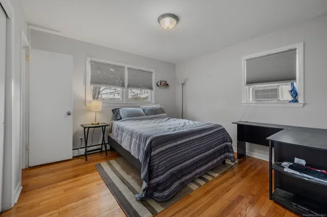 a bedroom with a bed and wooden floor