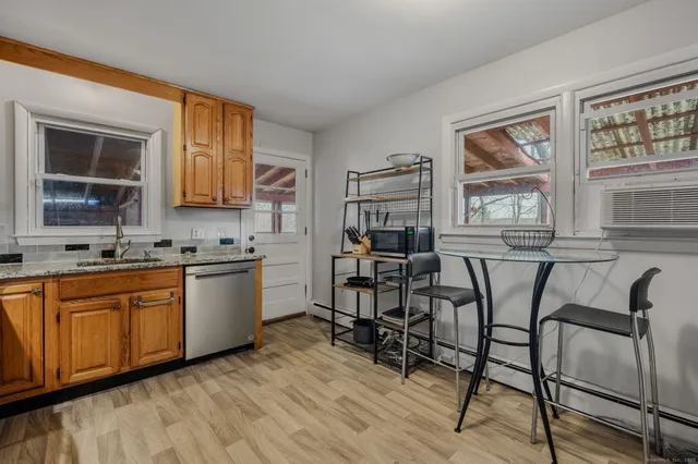 a view of a kitchen with granite countertop dining table chairs cabinets and a sink