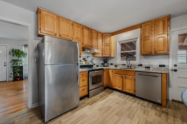 a kitchen with stainless steel appliances granite countertop a refrigerator stove microwave and sink
