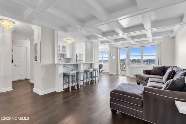 a living room with furniture wooden floor and a large window