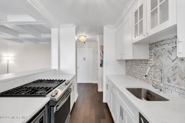 a kitchen with granite countertop a sink stove and cabinets