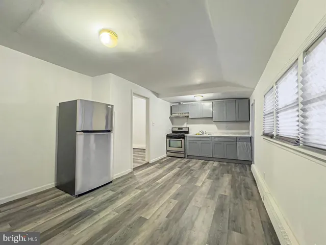 a kitchen with a refrigerator and white cabinets