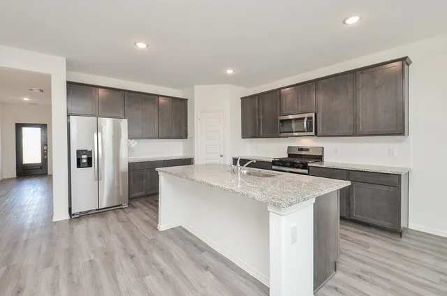 a kitchen with kitchen island a sink stainless steel appliances and cabinets