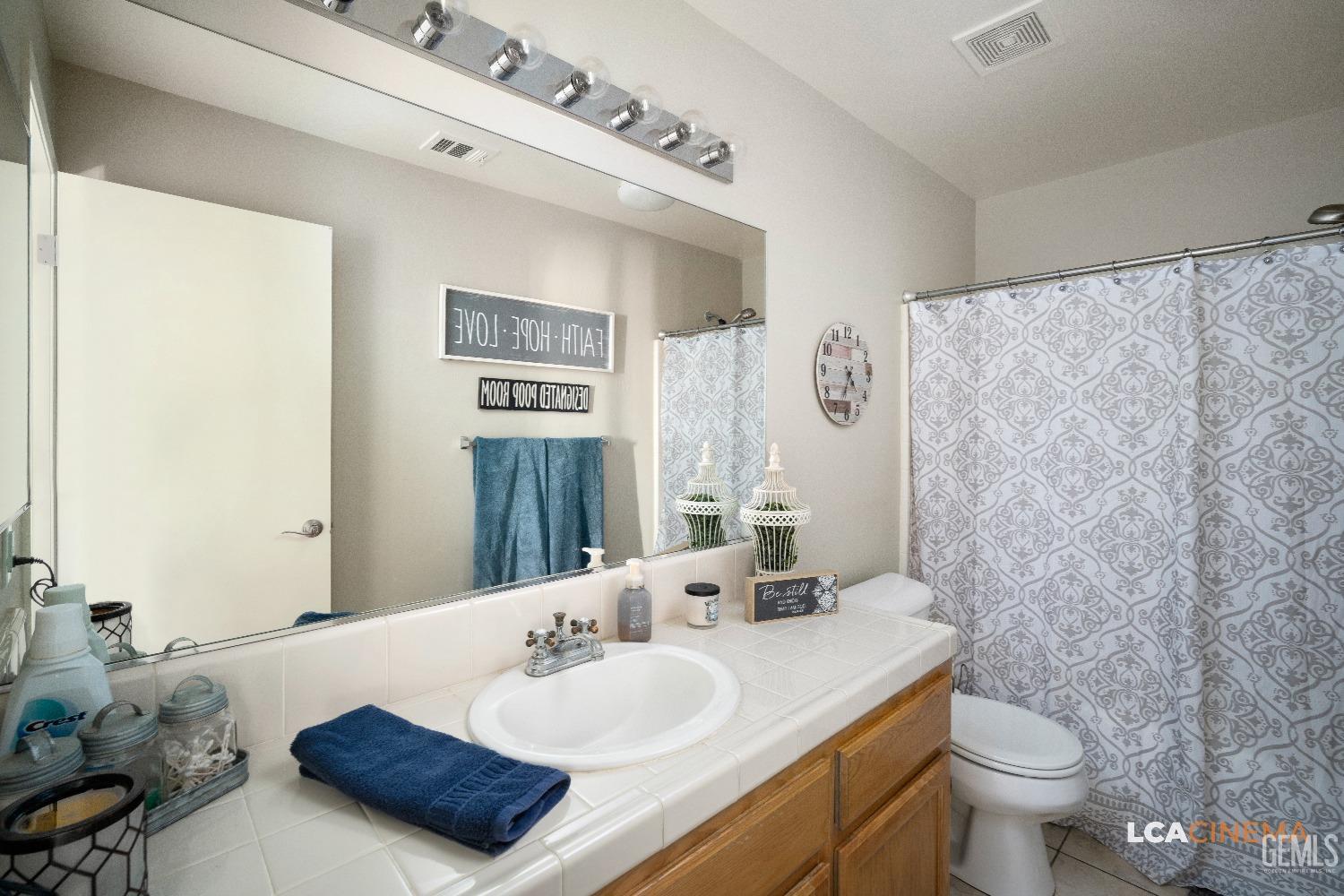 Undisclosed Address Bakersfield, CA 93311 - Photo 16 of 26 a bathroom with a granite countertop sink mirror vanity and toilet