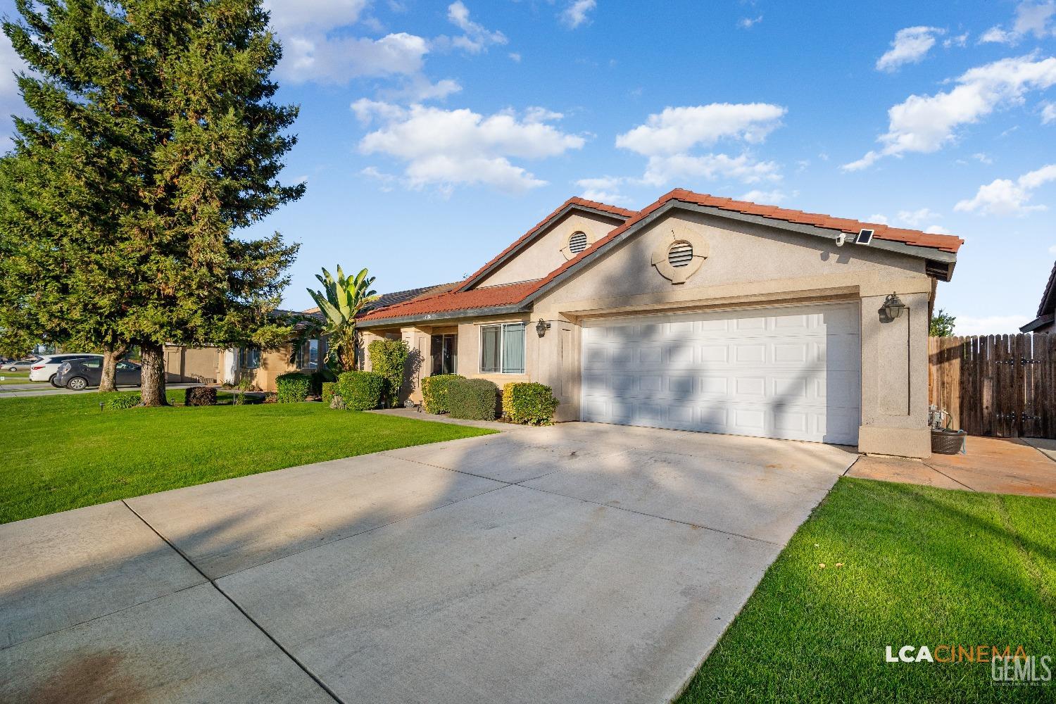 Undisclosed Address Bakersfield, CA 93311 - Photo 6 of 26 a front view of a house with a yard and garage