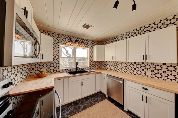 a kitchen with granite countertop a sink a stove cabinets and counter space