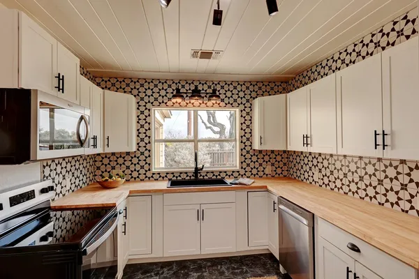 a kitchen with granite countertop a sink a stove and cabinets