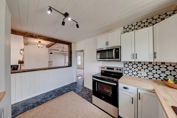 a kitchen with granite countertop a stove and a microwave
