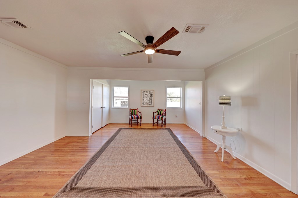102 Myrtle Avenue Harper, TX 78631 - Photo 26 of 49 a large bedroom with wooden floor and a ceiling fan