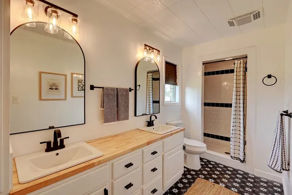 a bathroom with a double vanity sink mirror and toilet