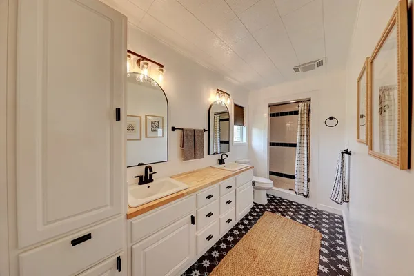 a spacious bathroom with double vanity and mirrors