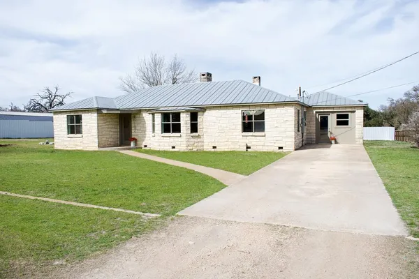 a front view of house with yard and green space