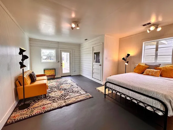 a bedroom with a bed couch and window