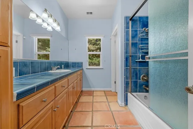 a bathroom with a double vanity sink and mirror with shower