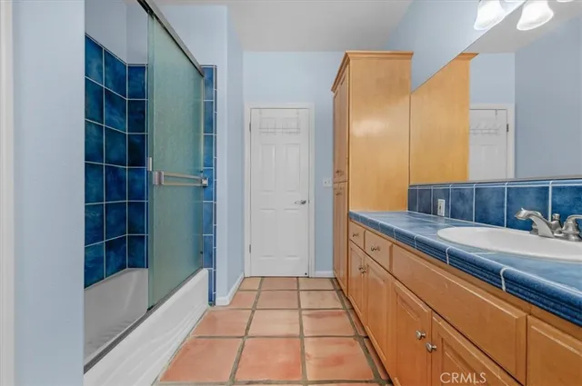 a bathroom with a granite countertop sink a toilet a mirror and tub