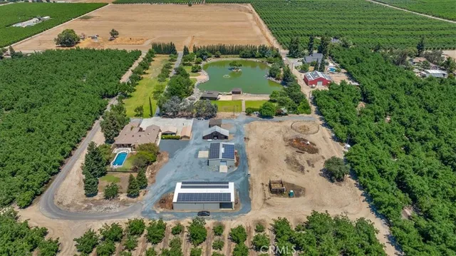 an aerial view of a house with a garden and fire pit