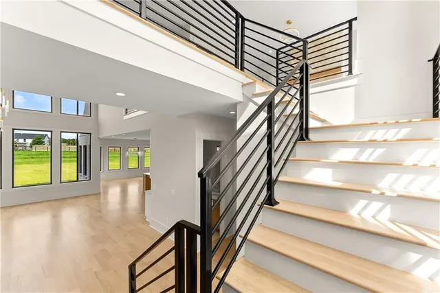 a view of an empty room with window and wooden floor