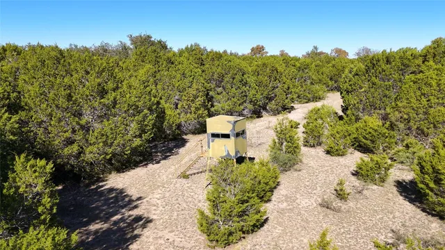 an aerial view of a houses with a street and green space