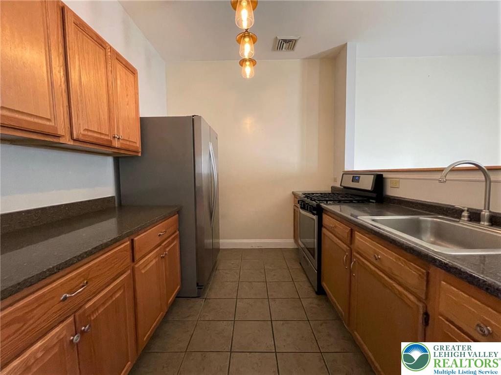 147 South 4th Street, Unit 14 Easton, PA 18042 - Photo 6 of 17 a kitchen with granite countertop a refrigerator and a sink
