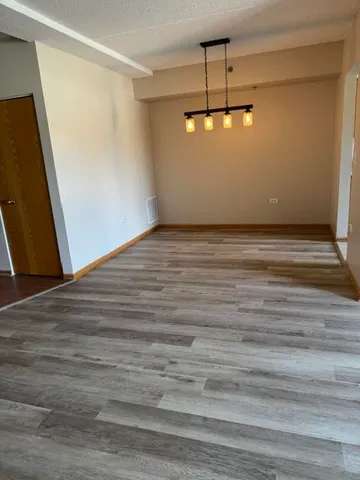 a view of a room with wooden floor and ceiling fan