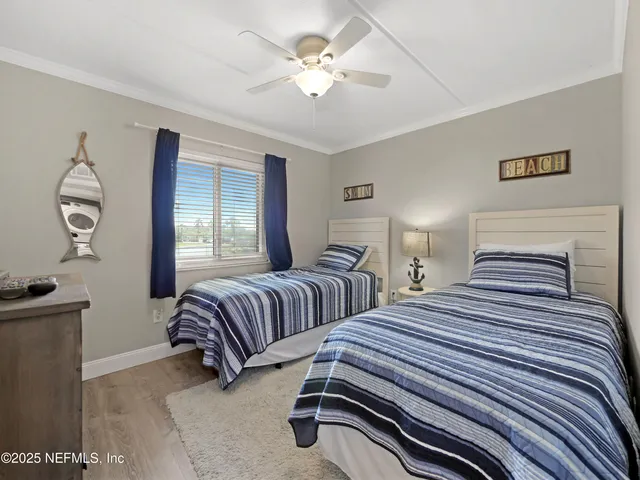 a bedroom with two beds and a chandelier