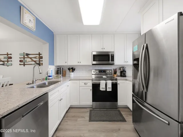 a kitchen with stainless steel appliances a refrigerator sink and microwave
