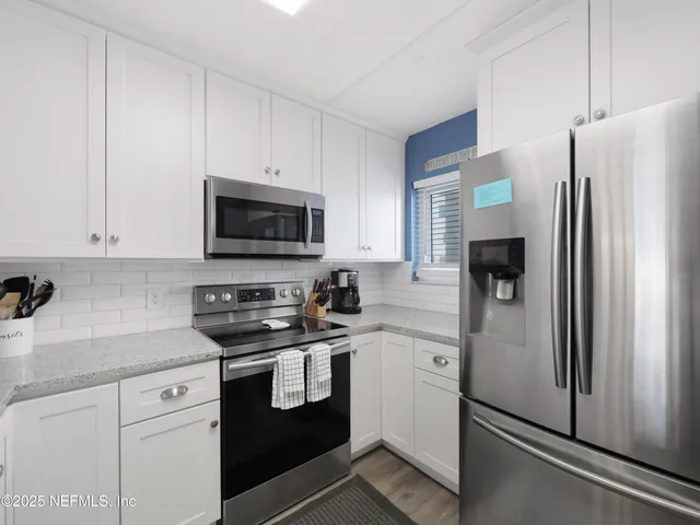 a kitchen with stainless steel appliances white cabinets and a refrigerator