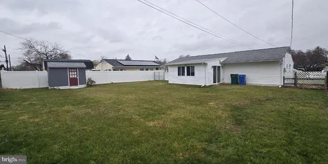 a view of a house with a big yard and large trees