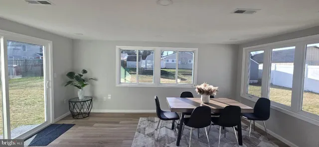 a dining room with furniture a chandelier and wooden floor