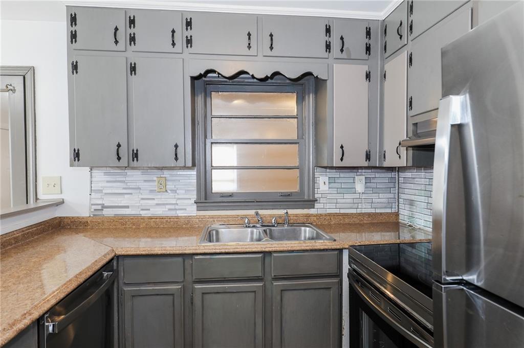 1678 Bagpipe Place Conley, GA 30288 - Photo 8 of 16 a kitchen with stainless steel appliances granite countertop a sink stove and cabinets