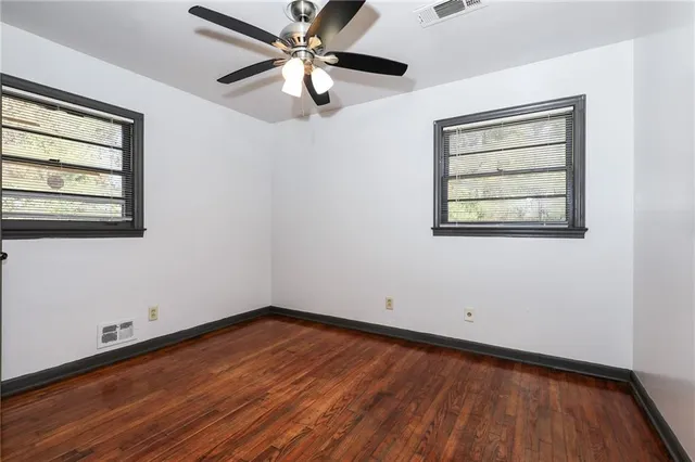 an empty room with a window and a ceiling fan