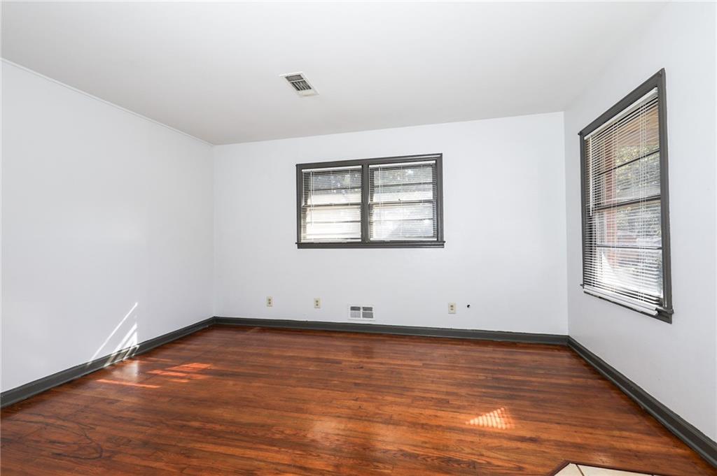 1678 Bagpipe Place Conley, GA 30288 - Photo 10 of 16 an empty room with wooden floor and windows