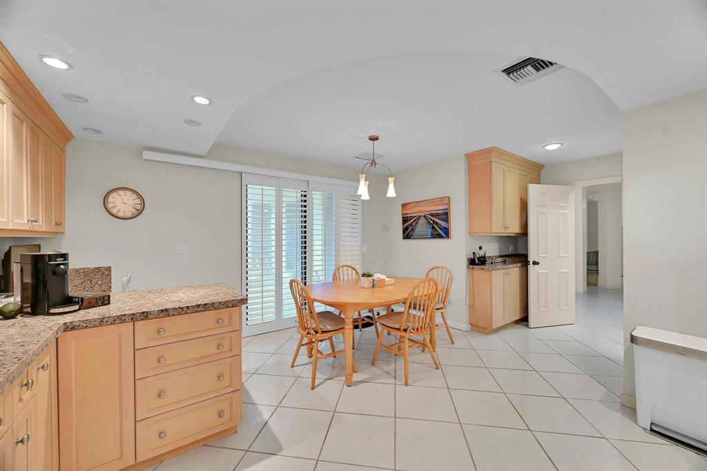 1171 North Ocean Boulevard, Unit 1A N Delray Beach, FL 33483 - Photo 11 of 41 a kitchen with stainless steel appliances kitchen island granite countertop a sink and cabinets
