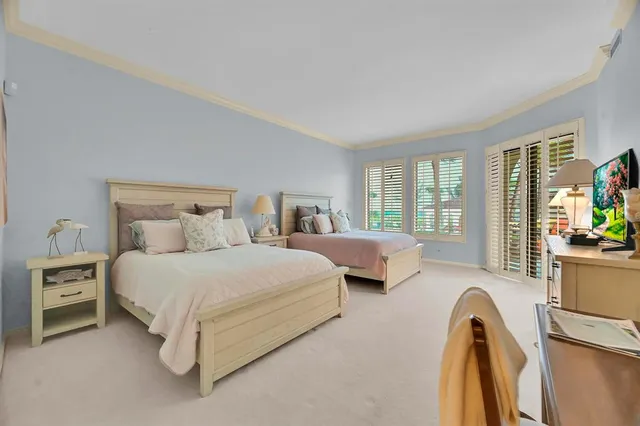 a spacious bedroom with two beds and chair