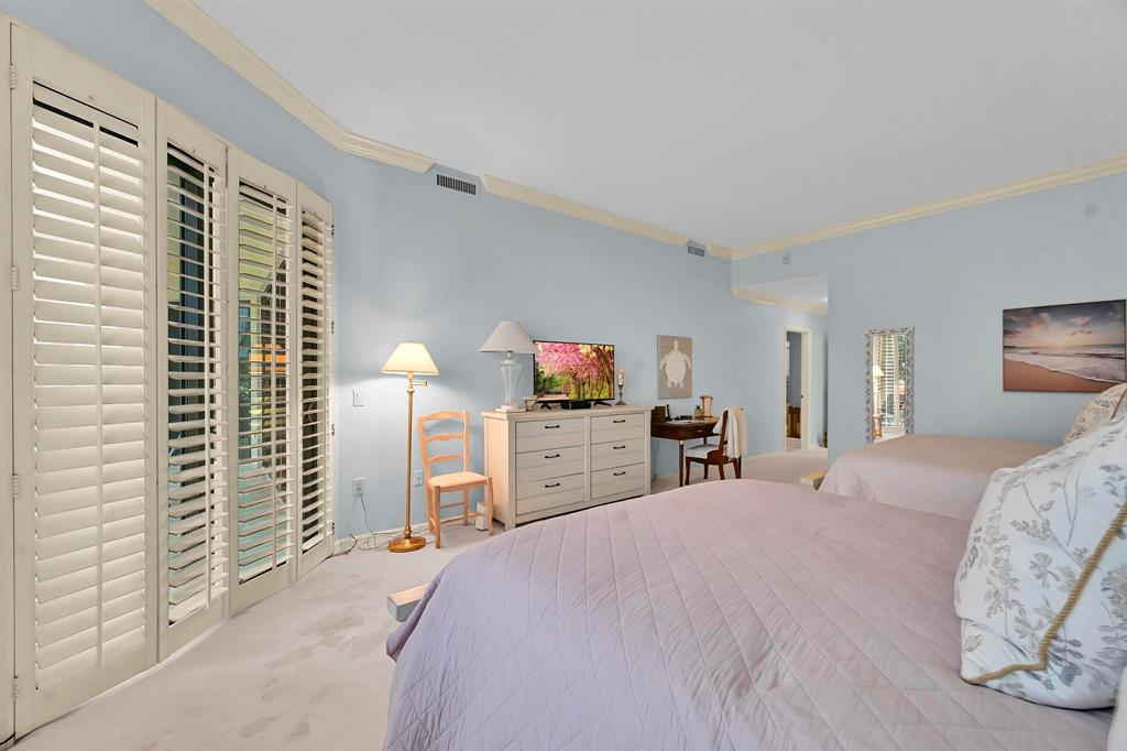 1171 North Ocean Boulevard, Unit 1A N Delray Beach, FL 33483 - Photo 20 of 41 a bedroom with a large bed and a chandelier