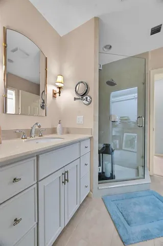a white toilet sitting next to a white sink and vanity