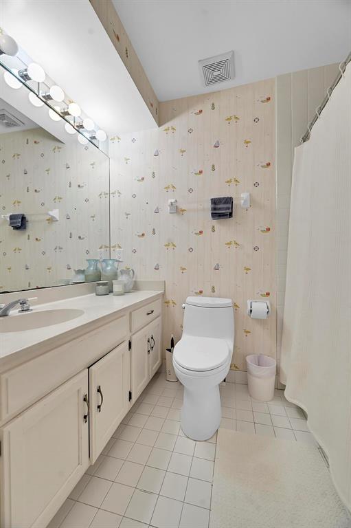 1171 North Ocean Boulevard, Unit 1A N Delray Beach, FL 33483 - Photo 31 of 41 a bathroom with a toilet sink and a mirror