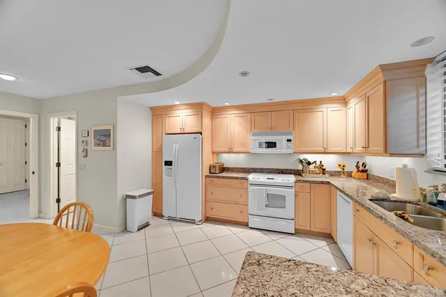 a kitchen with stainless steel appliances kitchen island granite countertop a sink and cabinets