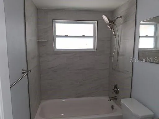 a bathroom with a bathtub sink vanity and window