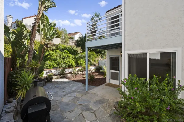 a backyard of a house with barbeque oven table and chairs