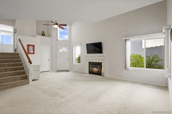 a view of an empty room with a fireplace and a window