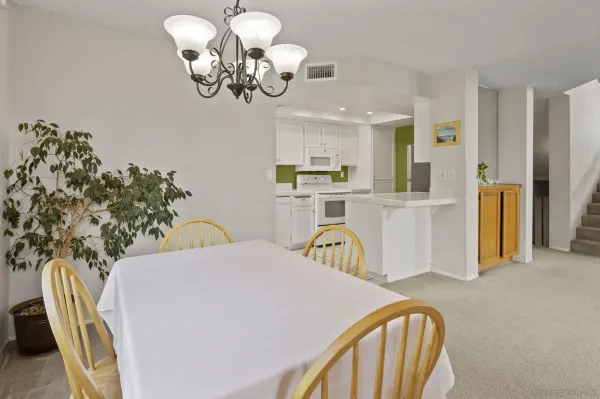 a view of a dining room with furniture a chandelier and wooden floor