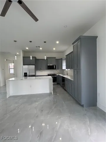 a large white kitchen with a large window and stainless steel appliances