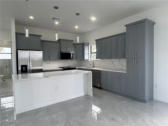 a kitchen with a sink cabinets stainless steel appliances and a counter top space